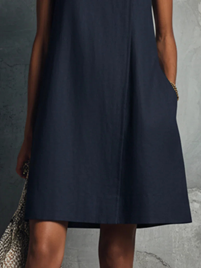 Mini-vestido de senhora em azul escuro, com decote redondo, fecho de botões assimétrico e bolso lateral