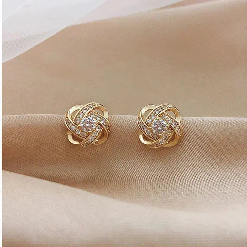 Brincos dourados em espiral floral com cristais