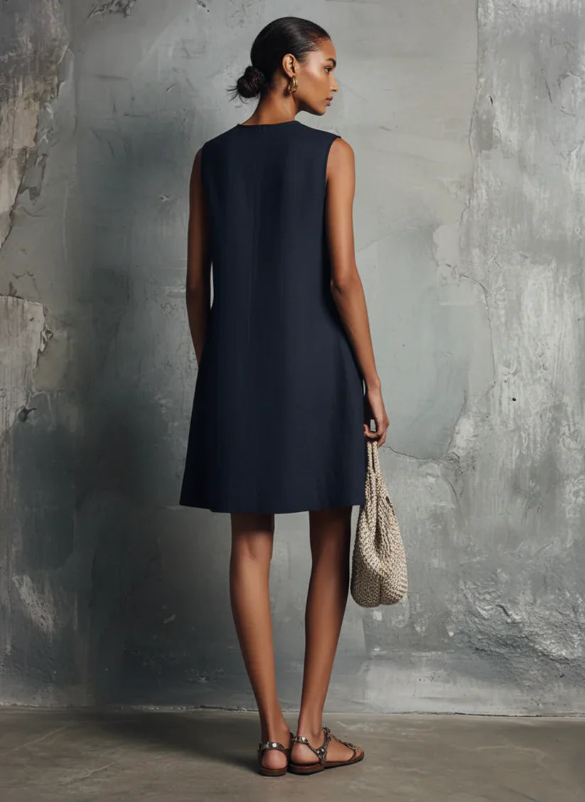 Mini-vestido de senhora em azul escuro, com decote redondo, fecho de botões assimétrico e bolso lateral